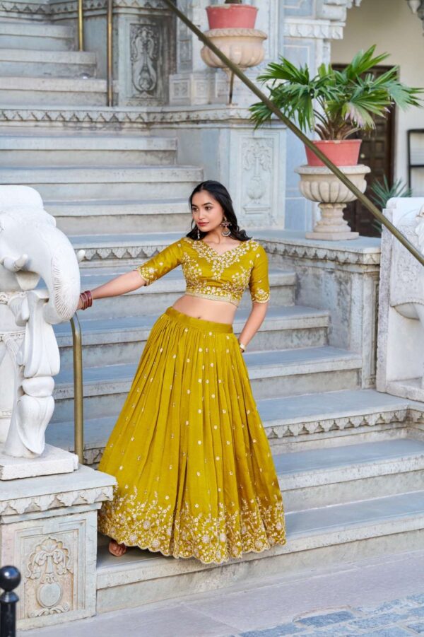 lnb - 1415   lnb 1415 thread embroidery work haldi special lehenga supplier surat 0 2025 06 02 16 03 49.jpg lnb 1415 thread embroidery work haldi special lehenga supplier surat Catalogue Name : 2nd Jun 2025 Name of Product : lnb - 1415  No of Design : 1 Piece (MOQ : 1 Set) Product Rate Per Piece : ₹ 1800 / Per Piece Product Full Catalogue Rate : ₹ 1800 (GST Extra) Full Catalogue Weight : 1 KG Product Type & Size: semi stitched Product Details: 
					 Wedding Collection 2025

A warm embrace of mustard and artistry 
 
LNB1415MST

Lehenga (Stitched)
Lehenga Fabric :  Vichitra Silk 
Lehenga work : Sequins and Thread Embroidery Work 
Lehenga Waist : SUPPORTED UP TO 42
Lehenga Closer : Drawstring with Zip 
Stitching : Stitched With Canvas and Can Can 
Length : 41
Flair : 3.5 Meter
Inner : Micro Cotton

Blouse (Unstitched)
Blouse Fabric :  Vichitra Silk 
Blouse Work : Sequins and Thread Embroidery Work 
Blouse Length : 1 Meter 

Dupatta
Dupatta Fabric :  Vichitra Silk   
Dupatta Work : Sequins and Thread Embroidery Work  Lace Border With Sequins Butties All Over  
Dupatta Length : 2.4 Meter

Package Contain: Lehenga, Blouse, Dupatta, Drawstring With Zip

Weight : 1.650 Kg

Price : 1800